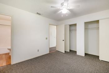 A room with a ceiling fan and carpeted floor